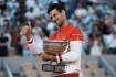Ilustrační foto - Srbský tenista Novak Djokovič pózuje s pohárem po svém vítězství na French Open.