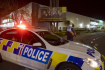 Policisté hlídkují u supermarketu v novozélandském Aucklandu, kde 3. září 2021 útočník pobodal nožem několik lidí.