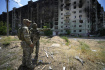 Ilustrační foto - Ruští vojáci u zničených obytných budov v ukrajinském Severodoněcku, 12. července 2022.