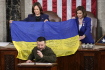 Ukrajinský prezident Volodymyr Zelenskyj při svém projevu v americkém Kongresu 22. prosince 2022. Vzadu drží ukrajinskou vlajku viceprezidentka USA Kamala Harrisová (vlevo) a šéfka Sněmovny reprezentantů Nancy Pelosiová.