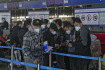 Čínští cestující v respirátorech na mezinárodním letišti v Pekingu 29. prosince 2022.