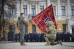 Ukrajinský prezident Volodymyr Zelenskyj drží vojenskou standartu při výročí ruské invaze v Kyjevě 24. února 2023.