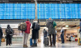 Cestující u tabule v odletové hale na letišti v Mnichově 10. března 2023.