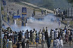 Policie v pákistánském Islámábádu rozhání slzným plynem demonstranty, kteří protestují proti zatčení bývalého premiéra Imrana Chána, 10. května 2023. 