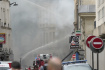 Hasiči bojují s požárem po výbuchu v centru Paříže a následném zhroucení budovy americké hudební školy. 21. června 2023. 