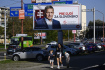 Žena s dětmi prochází kolem volebního billboardu strany Smer-SD s bývalým premiérem Robertem Ficem, 29. září 2023, Bratislava, Slovensko.