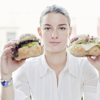 Mladá žena se sendviči, jídlo - ilustrační foto.