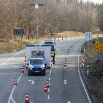 Němečtí policisté na hraničním přechodu v Neugersdorfu čekají na vozy přijíždějící z Česka 28. března 2021.