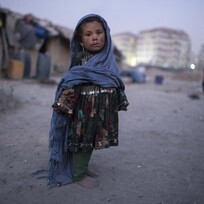 Ilustrační foto - Dívka před provizorním obydlím v Kábulu, kde mnozí lidé přejívají několik let. 
