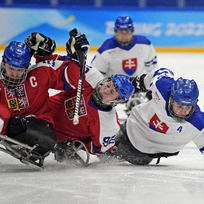 Čeští parahokejisté (zleva) Pavel Kubeš a Patrik Sedláček v souboji s Martinem Joppou ze Slovenska na paralympijských hrách v Pekingu.