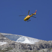 Záchranářský vrtulník nad ledovcem Punta Rocca u města Canizei v italských Dolomitech, kde se v neděli uvolnil velký kus ledovce.