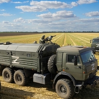 Ruští vojáci dohlížejí na sklizeň pšenice na poli poblíž Melitopolu na jihu Ukrajiny, 14. července 2022.
