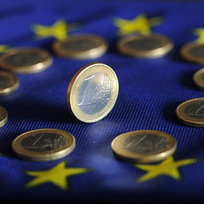 Jednoeurové mince na vlajce Evropské unie - ilustrační foto. 