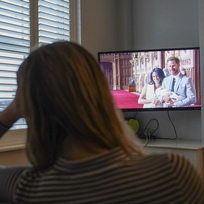 Žena v britském Warwicku sleduje dokumentární sérii o princi Harrym a jeho manželce Meghan na streamovací platformě Netflix, 8. prosince 2022.