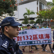 Policie sleduje demonstranty při shromáždění v Hongkongu, 26. března 2023.