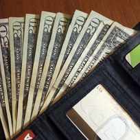 Dolarové bankovky v peněžence - ilustrační foto.