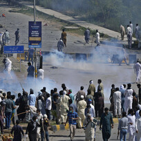 Policie v pákistánském Islámábádu rozhání slzným plynem demonstranty, kteří protestují proti zatčení bývalého premiéra Imrana Chána, 10. května 2023. 