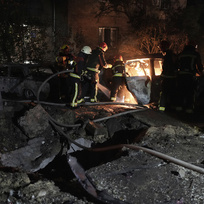 Hasiči zasahují v Kyjevě u požáru zaparkovaného automobilu, který zasáhly úlomky ruské rakety, 30. května 2023.