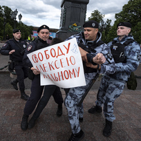 Ruští policisté zatýkají muže, který vyjadřuje podporu uvězněnému opozičnímu předákovi Alexeji Navalnému, 4. června 2023, Moskva.