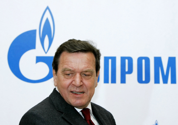 Bývalý německý kancléř Gerhard Schröder před logem ruského státního plynárenského podniku Gazprom. 