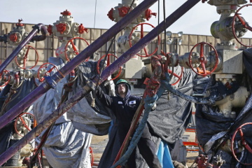 Pracovník upravuje potrubí během hydraulického štěpení (frakování) na vrtné plošině společnosti Encana Corp. poblíž města Mead ve státě Colorado. 