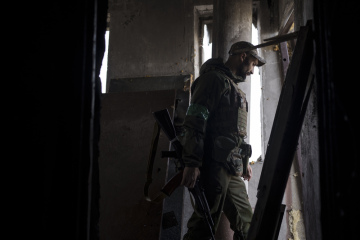 Ukrajinský voják chodí v budově poblíž frontové pozice v Charkově na Ukrajině, pondělí 25. dubna 2022.